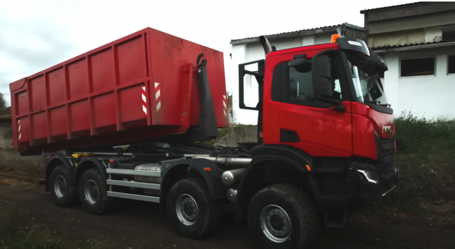 IVECO nákladní auto s techničákem na traktor v konfiguraci hákový nosič kontejnerů.