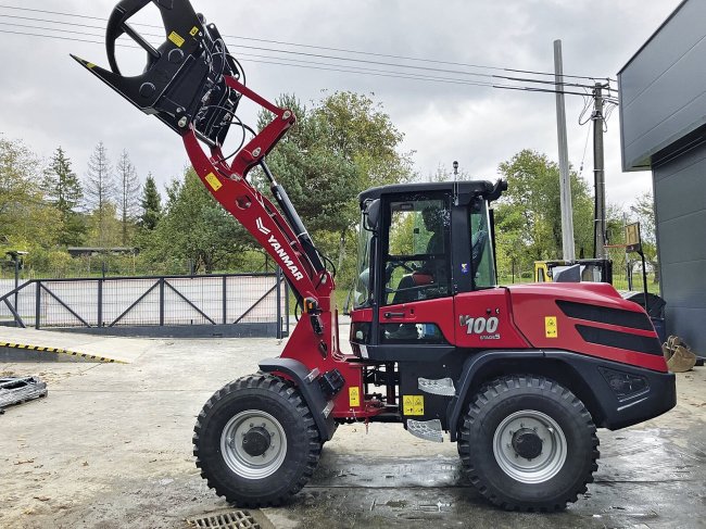 Yanmar V100 s drapákem pro manipulaci na dřevařském závodu či farmě.